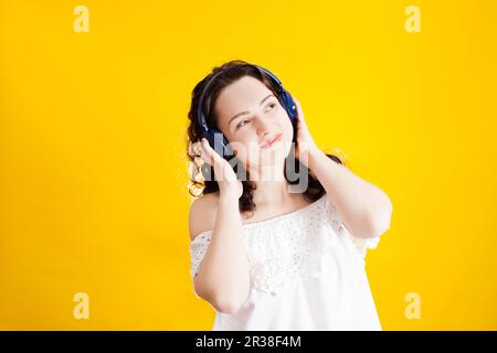 Donna che ascolta la musica con le cuffie wireless Foto Stock