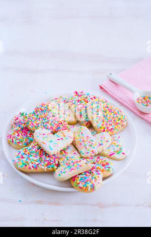 Biscotti a forma di cuore con spruzzi colorati Foto Stock