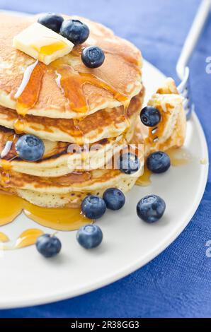 Una pila di tre pancake al mirtillo con sciroppo d'acero e succo d'arancia Foto Stock