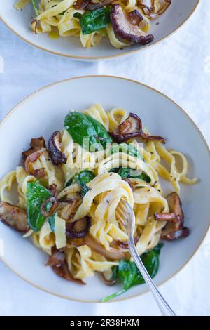 Fettuccine con spinaci, funghi e cipolle caramellate Foto Stock