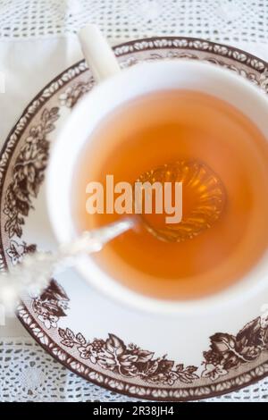 Tè in una tazza d'annata e un piattino Foto Stock