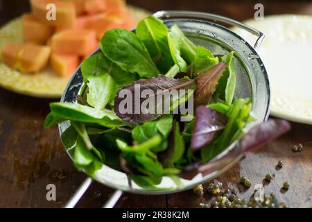 Ingredienti dell'insalata: Le foglie miste vengono lavate in un setaccio Foto Stock