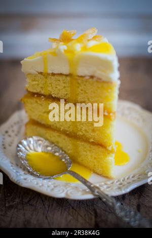 Una fetta di torta al limone a tre strati con glassa Foto Stock