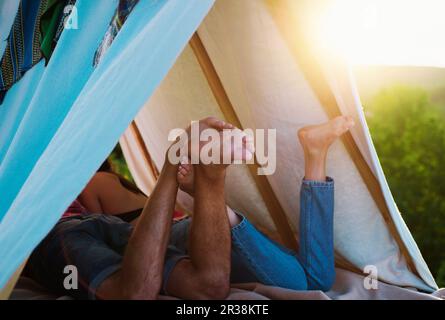 Coppia escursionisti campeggio sulla natura. Amanti romantici in vacanza campeggio. Vista posteriore gambe di coppia in tenda. Migliore amico. Concentrati sui piedi. Foto Stock