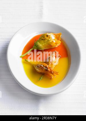 Fiori di zucchine ripieni in salsa di pepe rosso e giallo Foto Stock