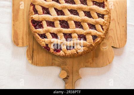 Linzertorte (torta di frutta secca e marmellata) su un asse di legno Foto Stock