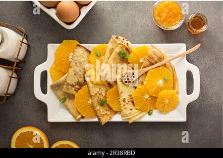 Crepes suzette crema con ripieno di formaggio e salsa di arancio e le arance fresche Foto Stock