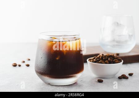 Caffè ghiacciato, caffè Cold Brew con ghiaccio su sfondo grigio chiaro brillante, bevanda rinfrescante Foto Stock