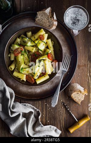 Rigatoni con zucchine al forno, pomodori ciliegini, timo, cipolla e spezie Foto Stock