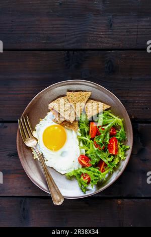 Colazione vegetariana con uova fritte, insalata e cracker (vista dall'alto) Foto Stock
