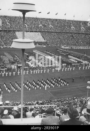 Olimpiadi di Berlino 1936. Le Olimpiadi estive del 1936 (in tedesco: Olimpiadi Sommerspiele 1936), ufficialmente note come i Giochi dell'XI Olimpia (in tedesco: Spiele der XI. Olympiade), comunemente conosciuta come Berlino 1936, è stata una manifestazione internazionale multisport tenutasi dal 1 al 16 agosto 1936 a Berlino, in Germania. Olympiastadion a Berlino uno stadio costruito per le olimpiadi estive del 1936 con spazio per 100 000 persone e la grande apertura dei Giochi olimpici del 1 agosto 1936. Foto Stock