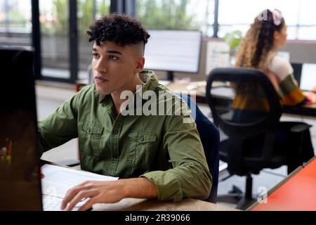 Occupati diversi uomini d'affari che lavorano alla scrivania utilizzando computer in ufficio creativo, inalterato Foto Stock