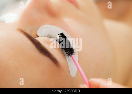 Occhio Donna primo piano durante l'estensione Eyelash Foto Stock