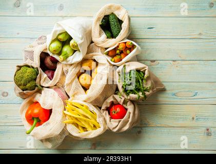 Verdure fresche in sacchetti di cotone eco sul tavolo vista dall'alto Foto Stock