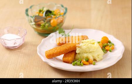 Barrette di pesce e purè di patate con un medley di piselli e carote Foto Stock