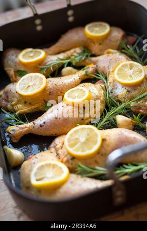 Cosce di pollo con limoni e rosmarino Foto Stock