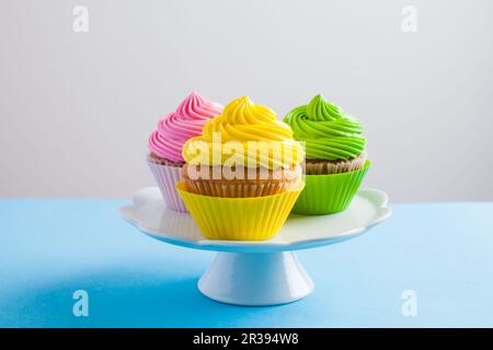 Cupcake con formaggio cremoso sul supporto per torte bianche Foto Stock