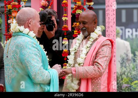 Londra, Regno Unito. 22 maggio 2023: Scambio di anelli di nozze. La cerimonia nuziale del presentatore del BBCÕs Your Garden Made Perfect e del Channel 4Õs Garden of the Year, Manoj Malde e Clive Gillmor si svolge al Chelsea Flower Show, una prima edizione della storia di 110 anni dell'evento. Il matrimonio si svolge nella RHS e nell'Eastern Eye Garden of Unity, che è decorato con uno schema di colori di marigolds arancione e rosa utilizzati nel culto indù. Credit: Dinendra Haria/Alamy Live News Foto Stock