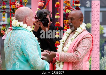 Londra, Regno Unito. 22 maggio 2023: Scambio di anelli di nozze. La cerimonia nuziale del presentatore del BBCÕs Your Garden Made Perfect e del Channel 4Õs Garden of the Year, Manoj Malde e Clive Gillmor si svolge al Chelsea Flower Show, una prima edizione della storia di 110 anni dell'evento. Il matrimonio si svolge nella RHS e nell'Eastern Eye Garden of Unity, che è decorato con uno schema di colori di marigolds arancione e rosa utilizzati nel culto indù. Credit: Dinendra Haria/Alamy Live News Foto Stock