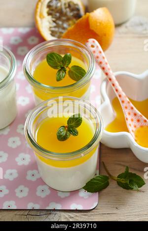 Panna cotta al cocco con salsa di frutto della passione in vasetti Foto Stock