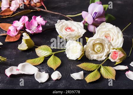 Vari fiori fatti a mano in schiuma di foamiran sul tavolo Foto Stock