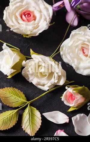 Vari fiori fatti a mano in schiuma di foamiran sul tavolo Foto Stock