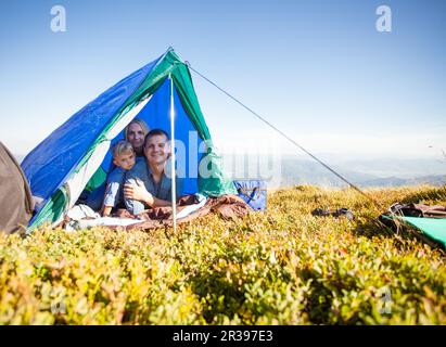 La famiglia guarda fuori dalla tenda Foto Stock