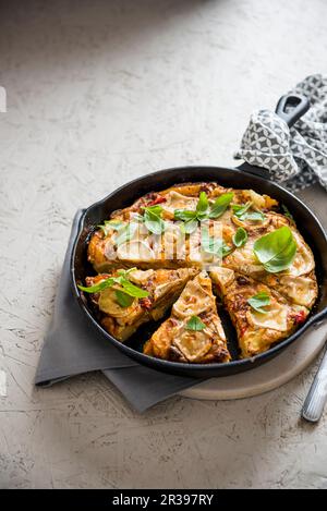 Tortilla spagnola di patate con peperoni rossi e formaggio di capra Foto Stock