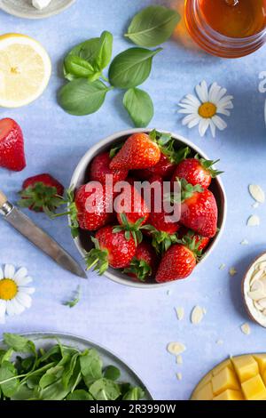 Piccola ciotola di fragole fresche su uno sfondo vibrante Foto Stock