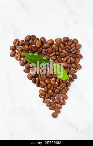 Ripresa dall'alto manciata pila di chicchi di caffè tostati isolate su sfondo bianco Foto Stock