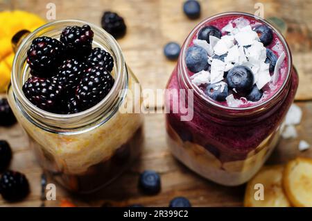 Un frullato di mirtillo e banana con yogurt, e un frullato di banana e mango con cioccolato e more Foto Stock