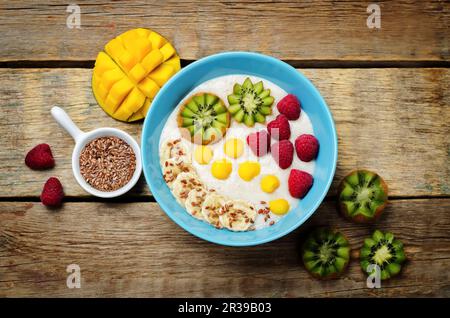 Colazione porridge di farinata d'avena con kiwi, mango, lampone, banana e semi di lino Foto Stock