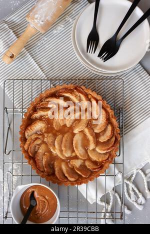 Torta di mele con salsa al caramello su una rastrelliera metallica (vista dall'alto) Foto Stock