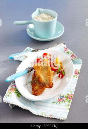 Filetto di spigola in una crosta di mandorle in una salsa alle erbe a base di maionese e yogurt Foto Stock