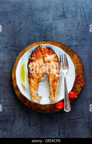 Bistecca di salmone alla griglia con limone, spezie e pomodori Foto Stock