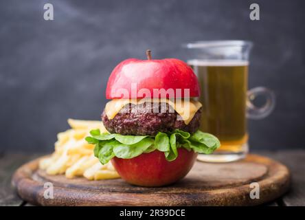 Hamburger con formaggio e insalata in mela, patatine frese, birra Foto Stock