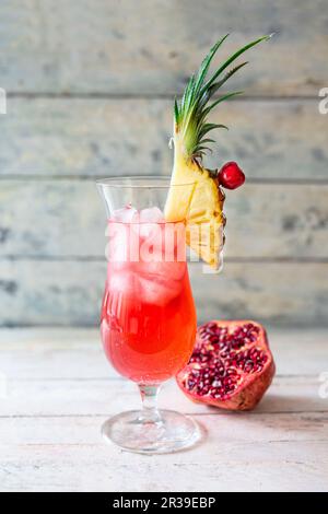 Singapore Sling in un bicchiere da cocktail guarnito con ananas Foto Stock