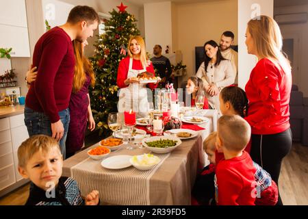 Un gruppo di amici si è riunito attorno al tavolo a Natale Foto Stock