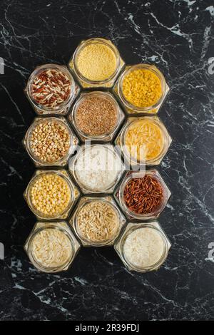 Vari cereali, riso, couscous, bulgur, e grano saraceno in vasi di vetro, vista dall'alto Foto Stock