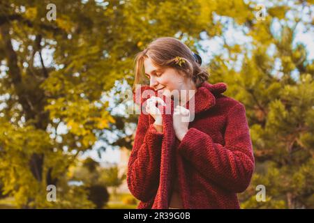 Donna attraente in cappotto vintage nella foresta d'autunno Foto Stock