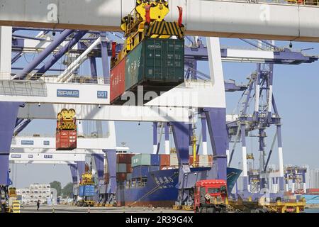 YANTAI, CINA - 22 MAGGIO 2023 - le gru caricano e scaricano i container al porto di Yantai, provincia di Shandong, Cina orientale, 22 maggio 2023. Nel primo aprile del 2 Foto Stock