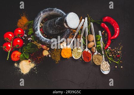 Sfondo di cibo con erbe aromatiche, spezie e mortaio di pietra Foto Stock