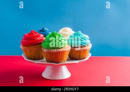 Cinque cupcake di compleanno su un cakestand bianco Foto Stock