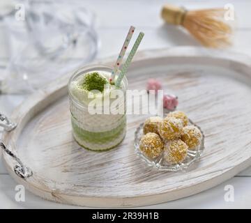 Latte di matta vegano con palle di mango e cocco su un vassoio Foto Stock