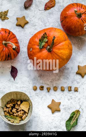 Biscotti sotto forma di stelle e lettere da cui viene scritta la parola ottobre, zucche e foglie autunnali Foto Stock