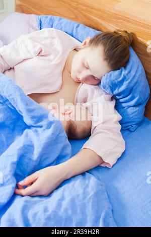 La madre si sentiva addormentata mentre allattava a letto Foto Stock