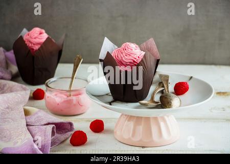 Deliziose tortine di glassa decorata con rosa di crema di formaggio e lampone Foto Stock