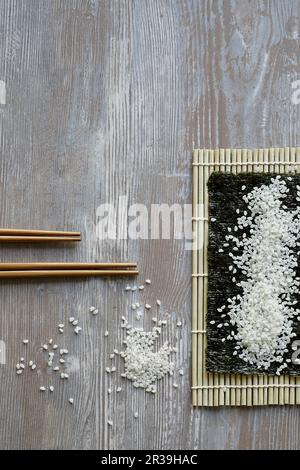 Riso sushi su una foglia di nori e un tappetino di bambù (Giappone) Foto Stock