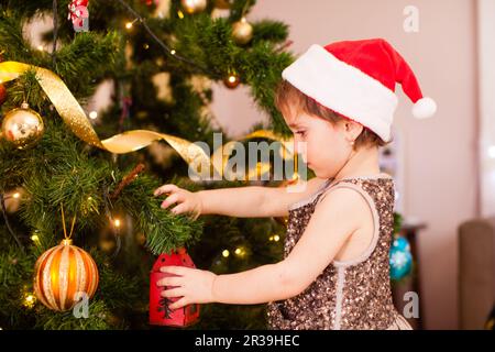 La bambina decora l'albero di Natale Foto Stock