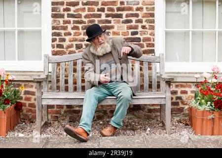 Il personaggio locale John Callaby nella foto si trova al di fuori dell'Alford Manor House nell'Alford Lincolnshire. John è ben noto ad Alford e si trova spesso fuori dalla Manor House e su panchine nel centro della città. E' ben noto per la sua caratteristica barba, cappello e pipa. E' piu' che felice di posare per fotografie ed e' parte della comunita' locale. Foto Stock